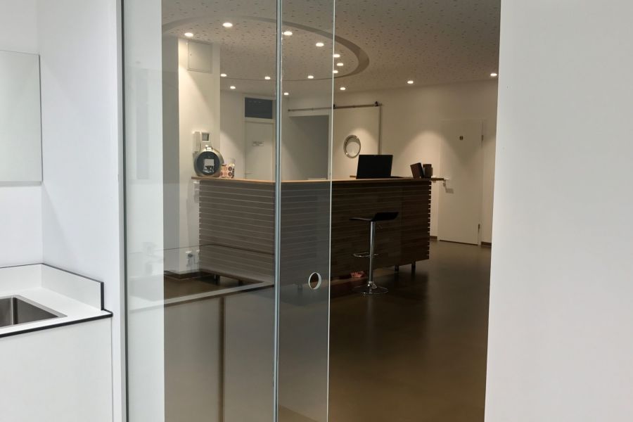 Blick durch die Glastür auf den Empfang der Praxis